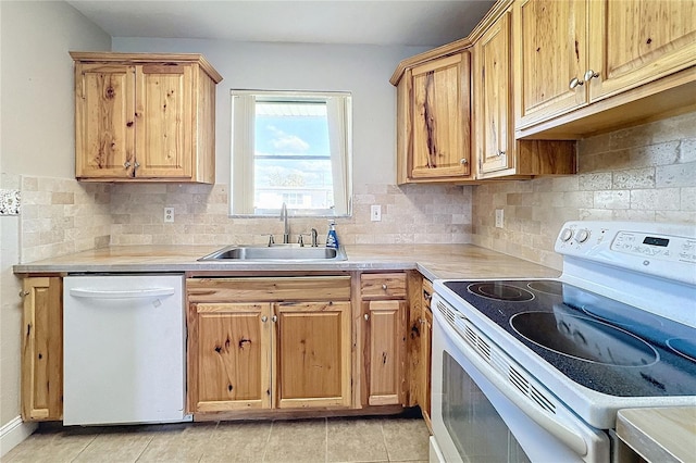 kitchen featuring tasteful backsplash, white appliances, sink, and light tile patterned floors