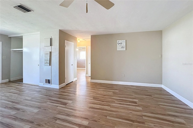 empty room featuring hardwood / wood-style flooring, ceiling fan, and a textured ceiling