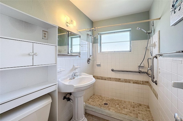 bathroom with tile walls, toilet, and a tile shower