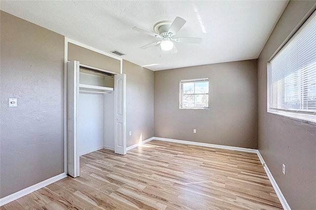 unfurnished bedroom featuring a closet, a textured ceiling, ceiling fan, and light hardwood / wood-style flooring