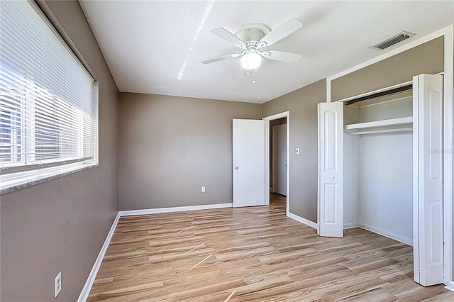 unfurnished bedroom with ceiling fan, a closet, and light wood-type flooring