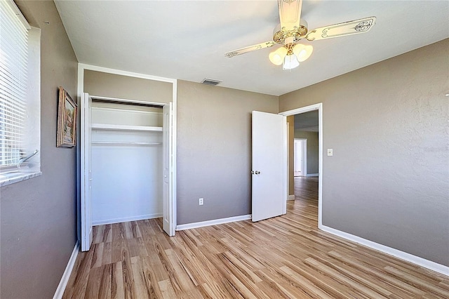 unfurnished bedroom with ceiling fan, a closet, and light hardwood / wood-style flooring