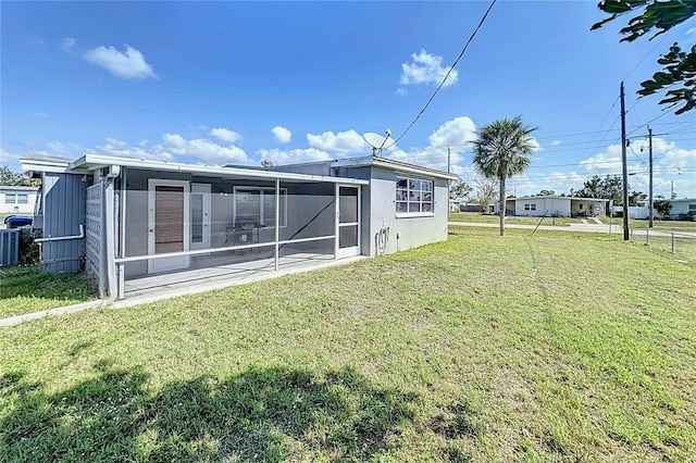 back of property featuring a yard, a sunroom, and central air condition unit