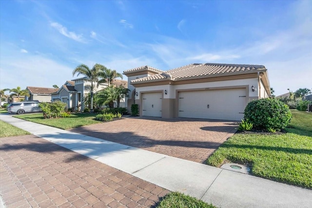 mediterranean / spanish house with a garage and a front lawn