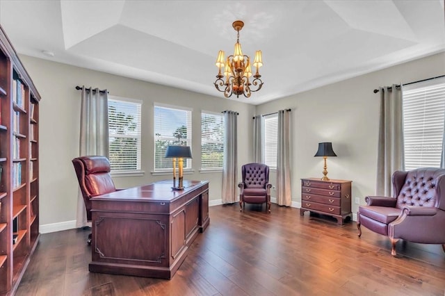 office area featuring a notable chandelier, dark wood-type flooring, and a raised ceiling