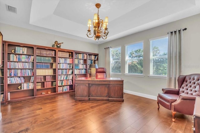 office with dark hardwood / wood-style floors, a chandelier, and a tray ceiling