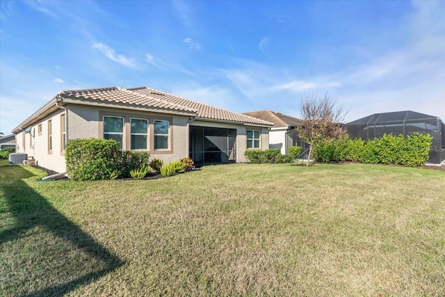 back of property with cooling unit and a yard