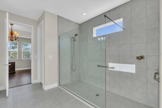 bathroom with tiled shower and tile patterned flooring