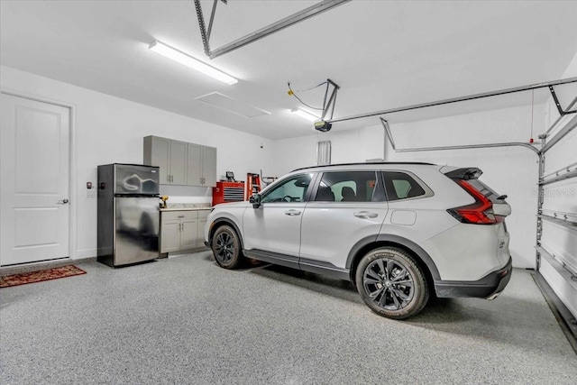 garage with a garage door opener and stainless steel fridge