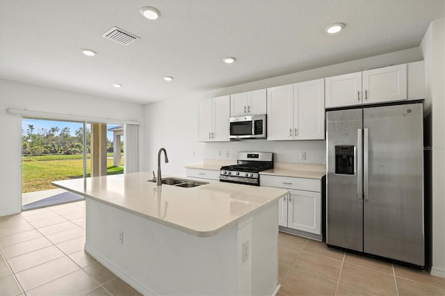 kitchen with white cabinetry, stainless steel appliances, a kitchen island with sink, and sink