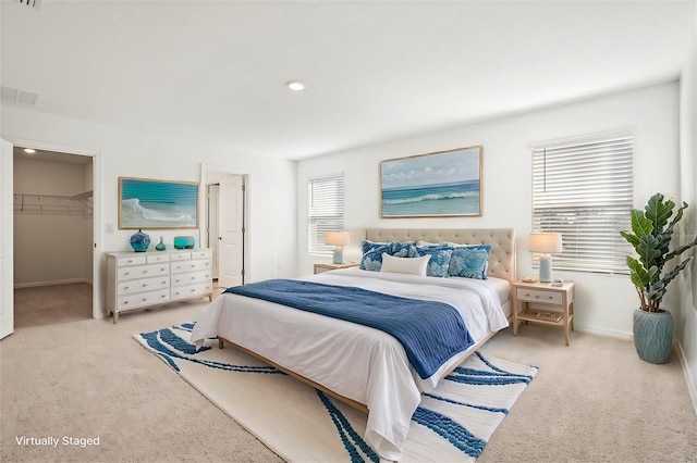 carpeted bedroom featuring a spacious closet and a closet