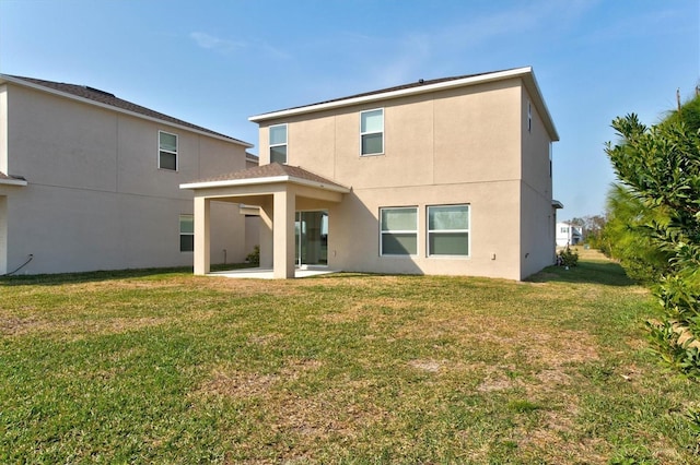 rear view of house with a lawn and a patio area