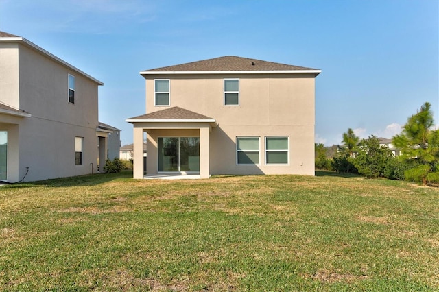 rear view of property featuring a lawn