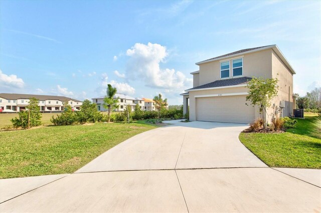 view of front of property featuring a garage, central AC, and a front yard