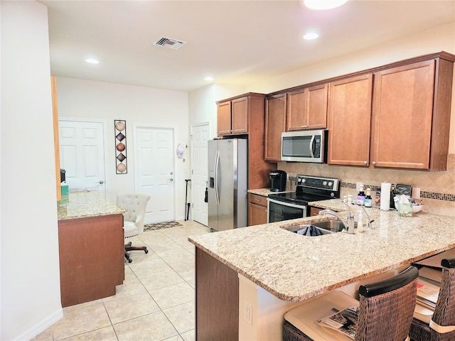 kitchen with sink, a kitchen breakfast bar, kitchen peninsula, and appliances with stainless steel finishes