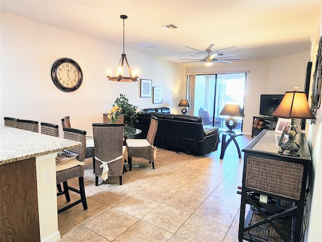 tiled living room featuring ceiling fan with notable chandelier