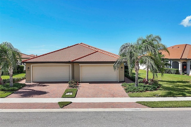 mediterranean / spanish home with a garage and a front yard