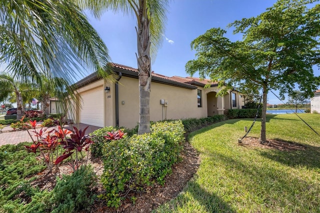 view of property exterior with a garage and a lawn