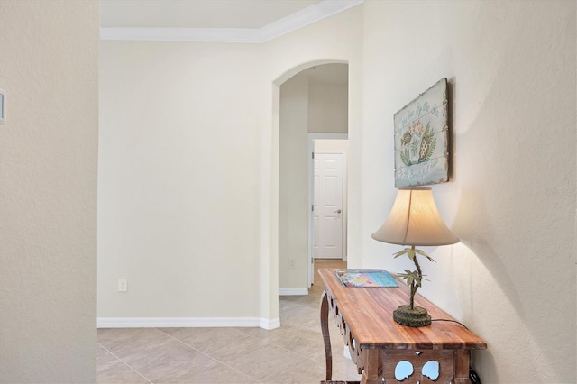 hall featuring light tile patterned floors and crown molding