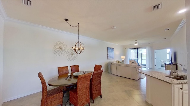 dining room featuring sink, ceiling fan with notable chandelier, and ornamental molding