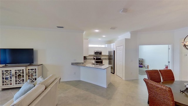 kitchen featuring stainless steel appliances, light stone countertops, ornamental molding, white cabinets, and kitchen peninsula