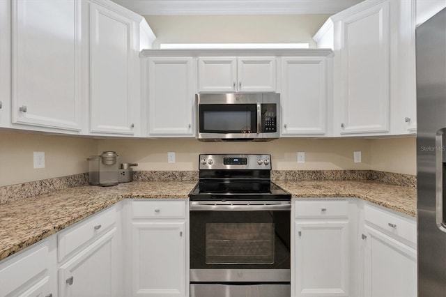 kitchen with white cabinetry, appliances with stainless steel finishes, and light stone counters