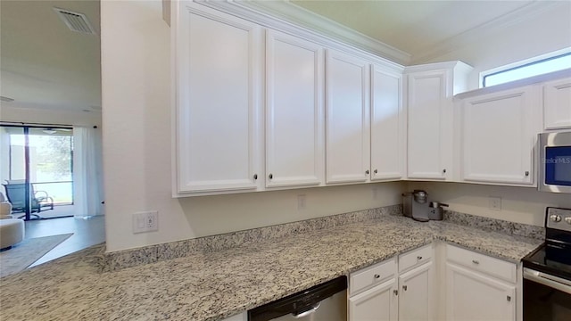 kitchen featuring appliances with stainless steel finishes, a wealth of natural light, and white cabinets