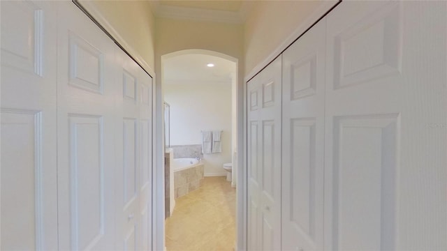 hall with crown molding and light tile patterned floors