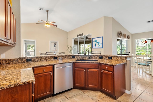 kitchen with lofted ceiling, sink, stainless steel dishwasher, and light stone counters