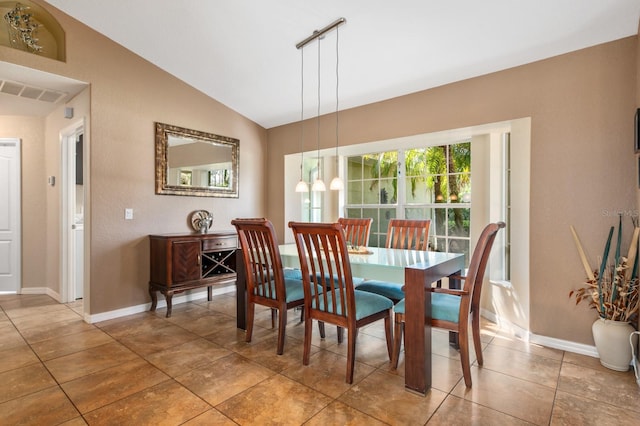 tiled dining room featuring lofted ceiling