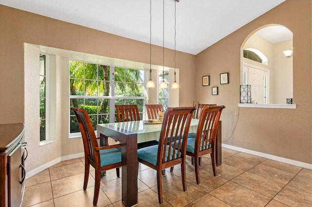 tiled dining room featuring lofted ceiling