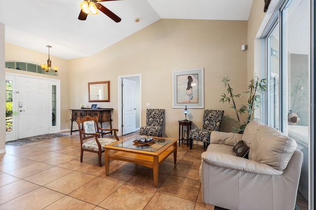 living room featuring light tile patterned flooring, ceiling fan with notable chandelier, and high vaulted ceiling