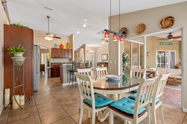 dining space with light tile patterned floors, vaulted ceiling, and ceiling fan