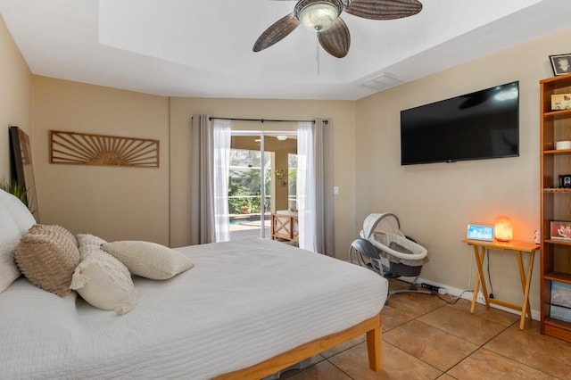 bedroom with ceiling fan, tile patterned floors, a tray ceiling, and access to outside