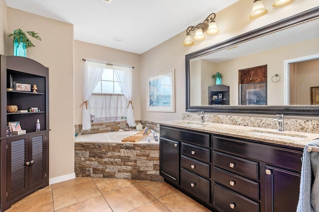 bathroom with tile patterned floors, vanity, and tiled bath