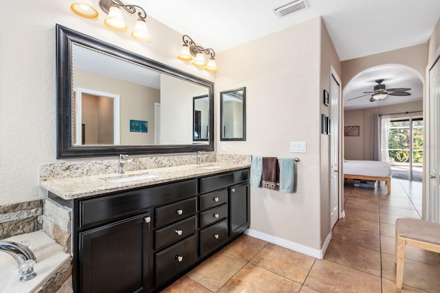 bathroom with ceiling fan, vanity, tiled bath, and tile patterned flooring