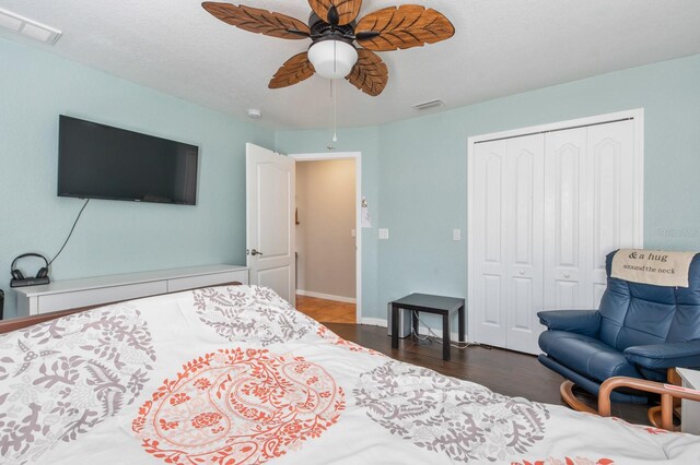 bedroom featuring ceiling fan, dark hardwood / wood-style flooring, and a closet