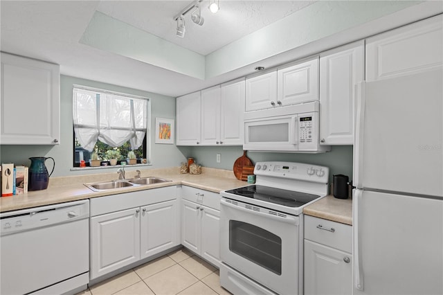 kitchen featuring light tile patterned flooring, sink, track lighting, white appliances, and white cabinets