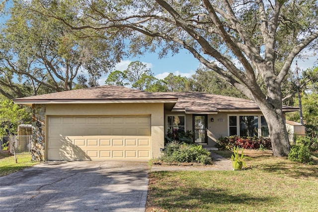 ranch-style house with a garage and a front lawn