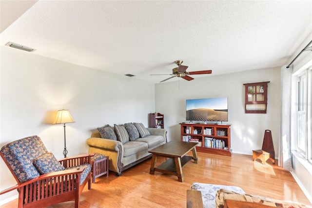 living room featuring light hardwood / wood-style floors, a textured ceiling, and a wealth of natural light