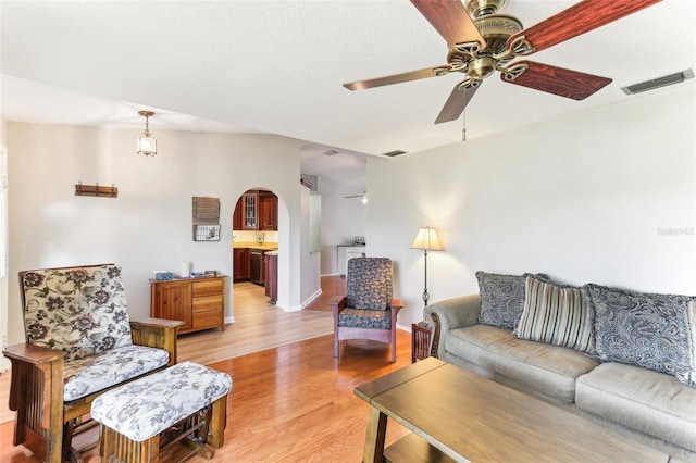 living room with ceiling fan and light wood-type flooring