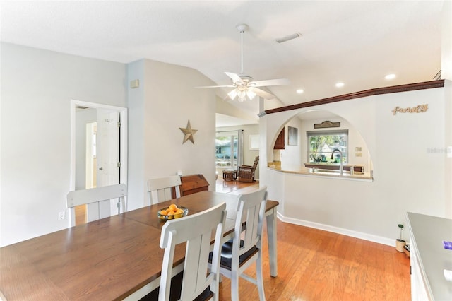 dining area with ceiling fan, lofted ceiling, sink, and light wood-type flooring