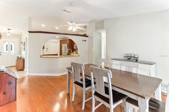 dining room featuring lofted ceiling, sink, ceiling fan, and light hardwood / wood-style flooring