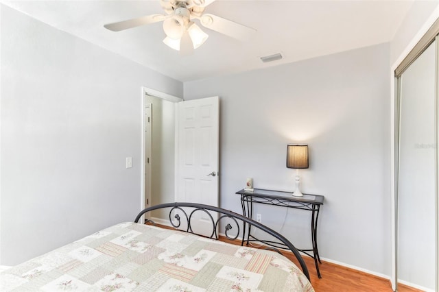 bedroom with light hardwood / wood-style floors, a closet, and ceiling fan