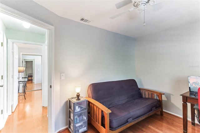 living area with wood-type flooring and ceiling fan