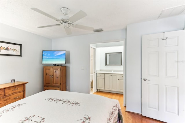 bedroom with ceiling fan, ensuite bathroom, and light hardwood / wood-style floors