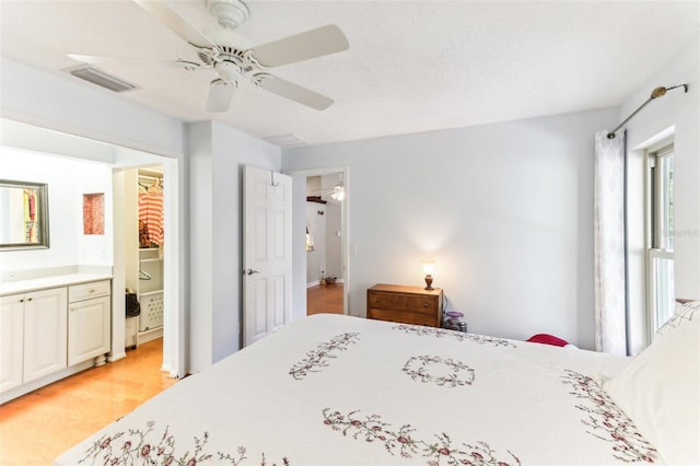 bedroom featuring ceiling fan, connected bathroom, and light wood-type flooring