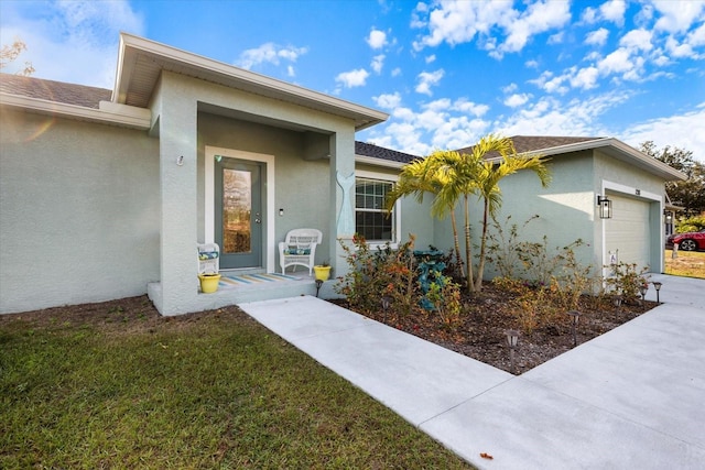 doorway to property with a garage and a lawn