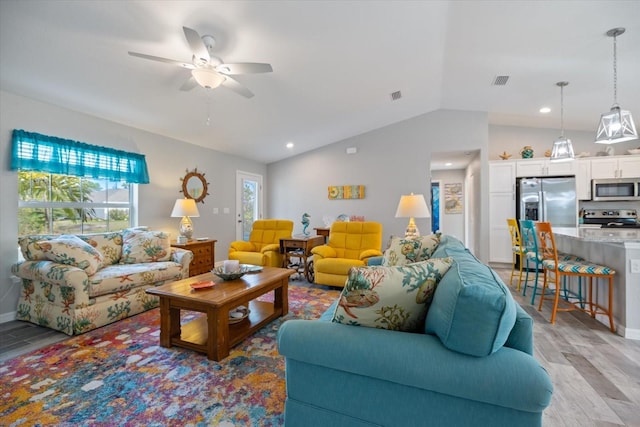 living room with vaulted ceiling, light hardwood / wood-style floors, and ceiling fan