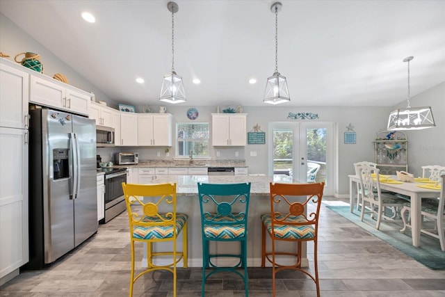 kitchen with a kitchen island, white cabinetry, appliances with stainless steel finishes, and french doors